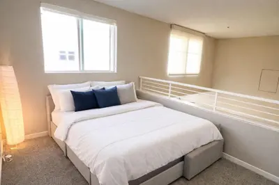 a bedroom with a large white bed with blue pillows at Luxury Residence Loft 3 Beds with Pool and Gym in Los Angeles