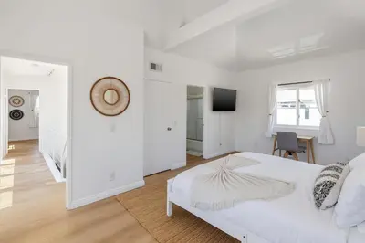 a white bedroom with a bed and a tv at Exclusive 2BD 3BA with Balcony in Los Angeles