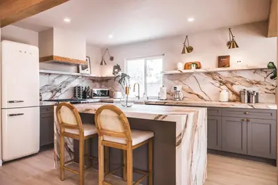 a kitchen with gray cabinets and a marble counter top at @ Marbella Lane - Vibrant & Chic Designer Home in Fullerton