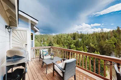 a balcony with a table and chairs and a grill at Deer Mountain in Lake Arrowhead
