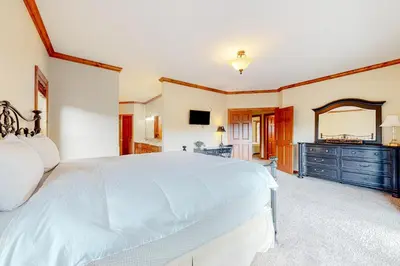 a large bedroom with a white bed and a dresser at Deer Mountain in Lake Arrowhead