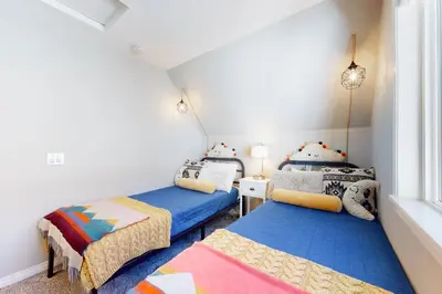 two twin beds in a room with a window at Hemlock Haven in Lake Arrowhead