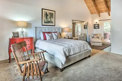 a bedroom with a bed and a chair in a room at Lovely Lake Arrowhead Cabin with Furnished Deck in Lake Arrowhead