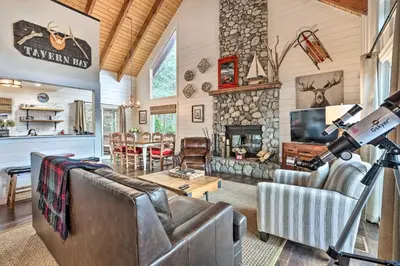 a living room with a couch and a fireplace at Lovely Lake Arrowhead Cabin with Furnished Deck in Lake Arrowhead