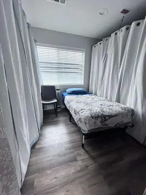 a room with two beds and a window with curtains at We are in this together in Santa Ana