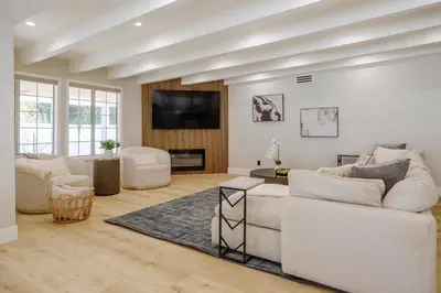 a living room with white furniture and a flat screen tv at New 5 bed w/hot tub close to Universal sleeps 12 in Los Angeles