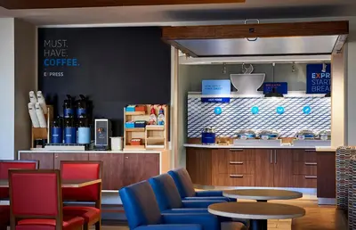 a coffee shop with blue chairs and a table at Holiday Inn Express & Suites - Glendale Downtown in Glendale