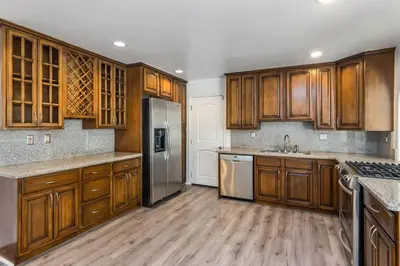 a kitchen with wooden cabinets and stainless steel appliances at Woodland Hills 3 bedroom w/ pool and spa in Los Angeles