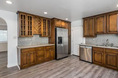 a kitchen with wooden cabinets and a stainless steel refrigerator at Woodland Hills 3 bedroom w/ pool and spa in Los Angeles