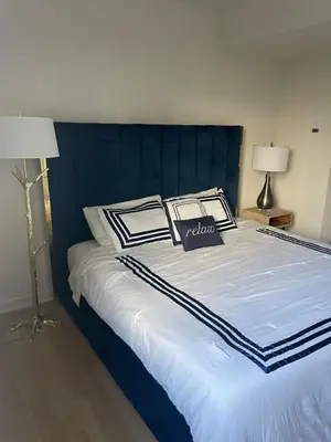 a bed with a blue headboard and two pillows on it at Super-Cute 2/2 apartment in Santa Monica with free parking in Los Angeles