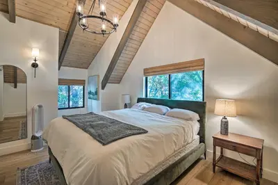 a bedroom with a large bed and a window at Pet-Friendly Retreat with Game Room and Fire Pit! in Lake Arrowhead