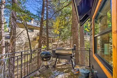 a grill on the balcony of a house at Pet-Friendly Retreat with Game Room and Fire Pit! in Lake Arrowhead