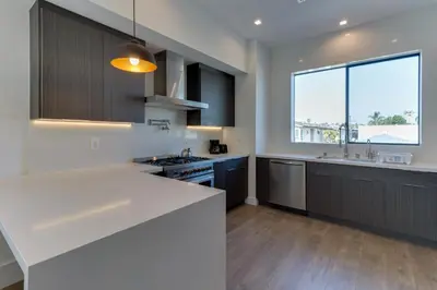 a kitchen with white counters and a large window at Modern 5 Bedroom Masterpiece With Rooftop Deck in Los Angeles