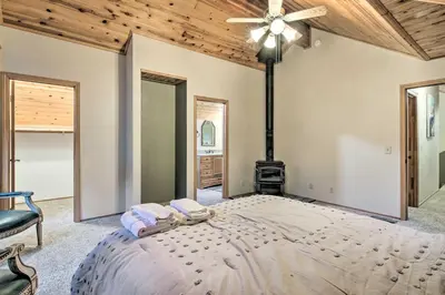 a bedroom with a large bed with a wood ceiling at Spacious Pine Mountain Club Cabin with Fire Pit in Pine Mountain Club