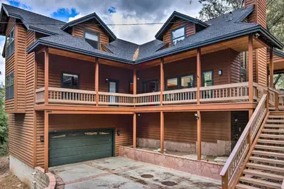 a large wooden house with a garage at Spacious Pine Mountain Club Cabin with Fire Pit in Pine Mountain Club