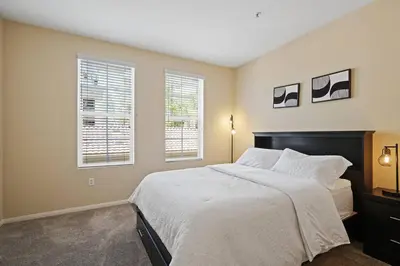 a bedroom with a large bed and two windows at Luxury 2BR/2BA!5Min to Disney! Angelstadium! HondaCenter. in Anaheim