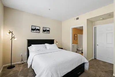 a bedroom with a large white bed and a bathroom at Luxury 2BR/2BA!5Min to Disney! Angelstadium! HondaCenter. in Anaheim