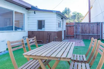 a wooden picnic table and two chairs in a yard at Newly Remodeled 2B1B House on Historic Route 66 in Glendora