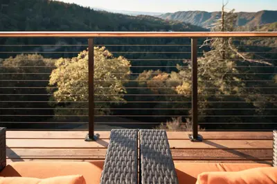 a bench sitting on top of a balcony with a view at Vista Haus in Crestline
