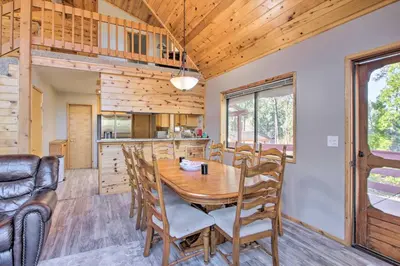 a dining room and kitchen with a wooden table and chairs at Idyllic Frazier Park Cabin Views, Pool Table in Frazier Park