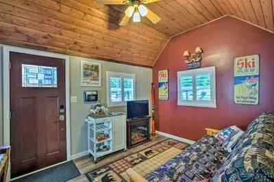 a living room with a couch and a tv at Running Springs Cabin with Deck and Forest Views in Running Springs