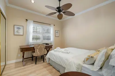 a bedroom with a bed and a desk with a ceiling fan at @ Marbella Lane - Captivating Home in Rowland Hts in Rowland Heights