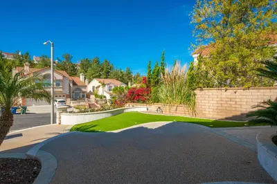 a driveway in a residential neighborhood with houses and trees at @ Marbella Lane - Captivating Home in Rowland Hts in Rowland Heights