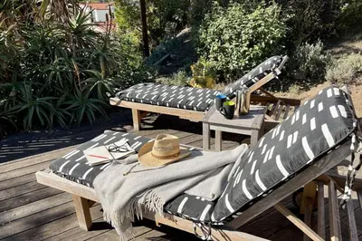 two benches sitting on a deck with a hat on them at Hollywood Hideaway in Los Angeles