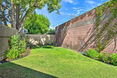a backyard with a fence and a yard with grass and flowers at 1 Mi to Dtwn Burbank Mod Gem with Private Yard in Burbank