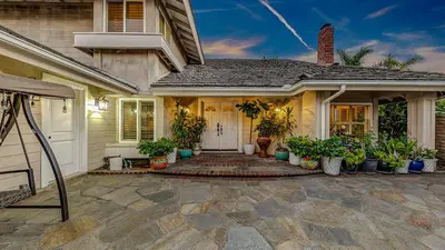 a house with potted plants on the front porch at Luxury Home 5 Bedrooms with Private Pool Near Huntington Beach in Santa Ana