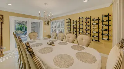 a dining room with a table and chairs and a chandelier at Luxury Home 5 Bedrooms with Private Pool Near Huntington Beach in Santa Ana