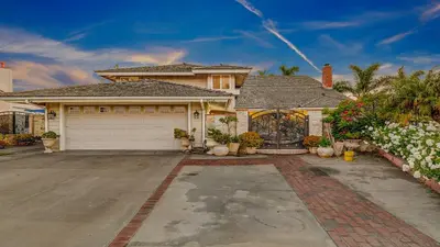 a house with a driveway and a garage at Luxury Home 5 Bedrooms with Private Pool Near Huntington Beach in Santa Ana