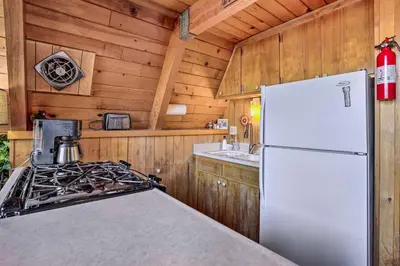 a kitchen with a white refrigerator and a stove at Cozy A-Frame with Hot Tub Near Arrowbear Lake! in Running Springs