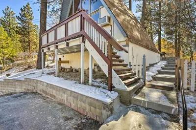 an exterior view of a house with a staircase at Cozy A-Frame with Hot Tub Near Arrowbear Lake! in Running Springs