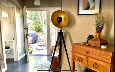 a room with a lamp on a dresser next to a door at Romantic cottage with amazing garden in Glendale