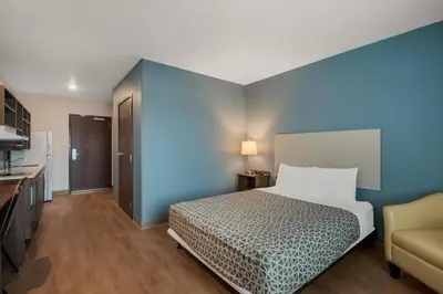 a hotel room with a bed and a couch at WoodSpring Suites Bellflower - Los Angeles in Bellflower