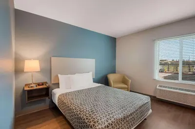 a small bedroom with a bed and a window at WoodSpring Suites Bellflower - Los Angeles in Bellflower