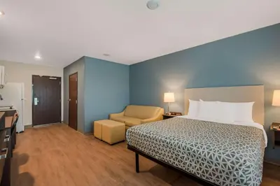 a hotel room with a bed and a chair at WoodSpring Suites Bellflower - Los Angeles in Bellflower