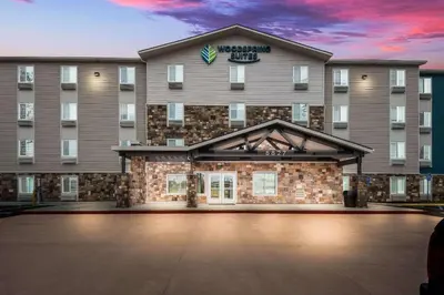 a rendering of the front of a hotel with a parking lot at WoodSpring Suites Bellflower - Los Angeles in Bellflower