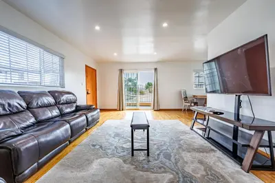 a living room with a leather couch and a flat screen tv at Spacious Two Bedroom in Santa Monica #E in Los Angeles