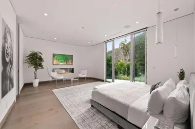 a white bedroom with a large bed and a desk at Chantilly Lace in Los Angeles