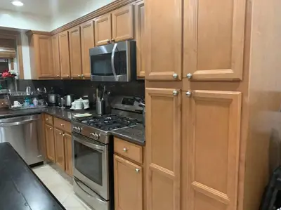 a kitchen with wooden cabinets and a stove top oven at Luxury Oasis Home w/Pool Near CSUN-6 Guests in North Hills