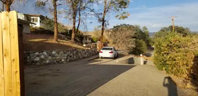 a white car parked in the driveway of a house at Panoramic Lake View, Lake Isabella in Wofford Heights