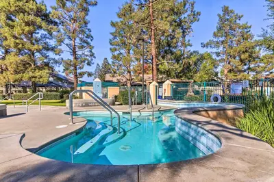 a pool with a slide in a park with trees at Family-Friendly Getaway Community Amenities! in Bakersfield