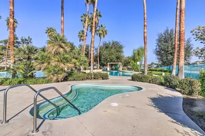a resort style swimming pool with palm trees at Family-Friendly Getaway Community Amenities! in Bakersfield