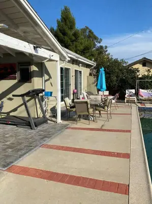 a patio with a table and chairs next to a house at Vacation Rental w Pool &Garden 6 Guests near CSUN in North Hills