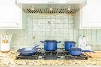 three pots and pans on a stove in a kitchen at Single Level House with view and pool in Glendora