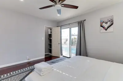 a bedroom with a white bed and a ceiling fan at 5 Bedroom Charmer with Pool in Reseda