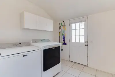 a kitchen with white cabinets and a dishwasher at 5 Bedroom Charmer with Pool in Reseda