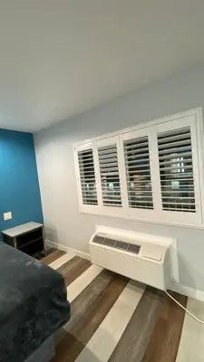a room with a bed and some windows at Plaza Inn Motel - Los Angeles area in Rosemead